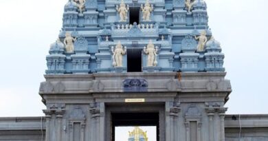 একজন ভক্ত তিরুপতির ভেঙ্কটেশ্বর মন্দিরের সামনে প্রার্থনায় রত, পেছনে মন্দিরের সুবিশাল গম্বুজ দৃশ্যমান।